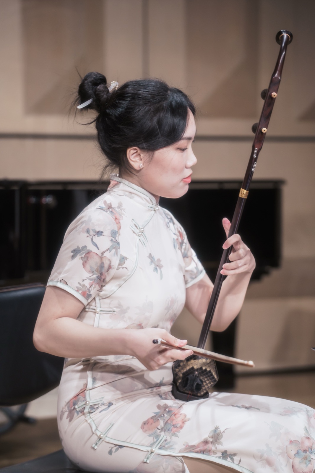 音樂會側拍作品 — 身著旗袍的二胡演奏者專注演奏