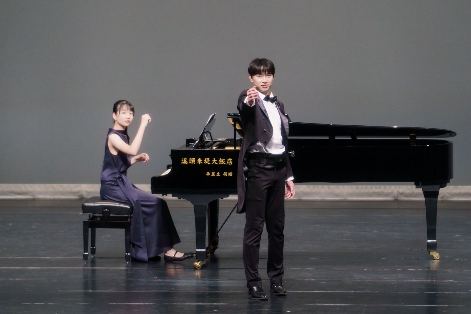 音樂會側拍作品 — 男聲獨唱者於平台鋼琴前的舞台演出